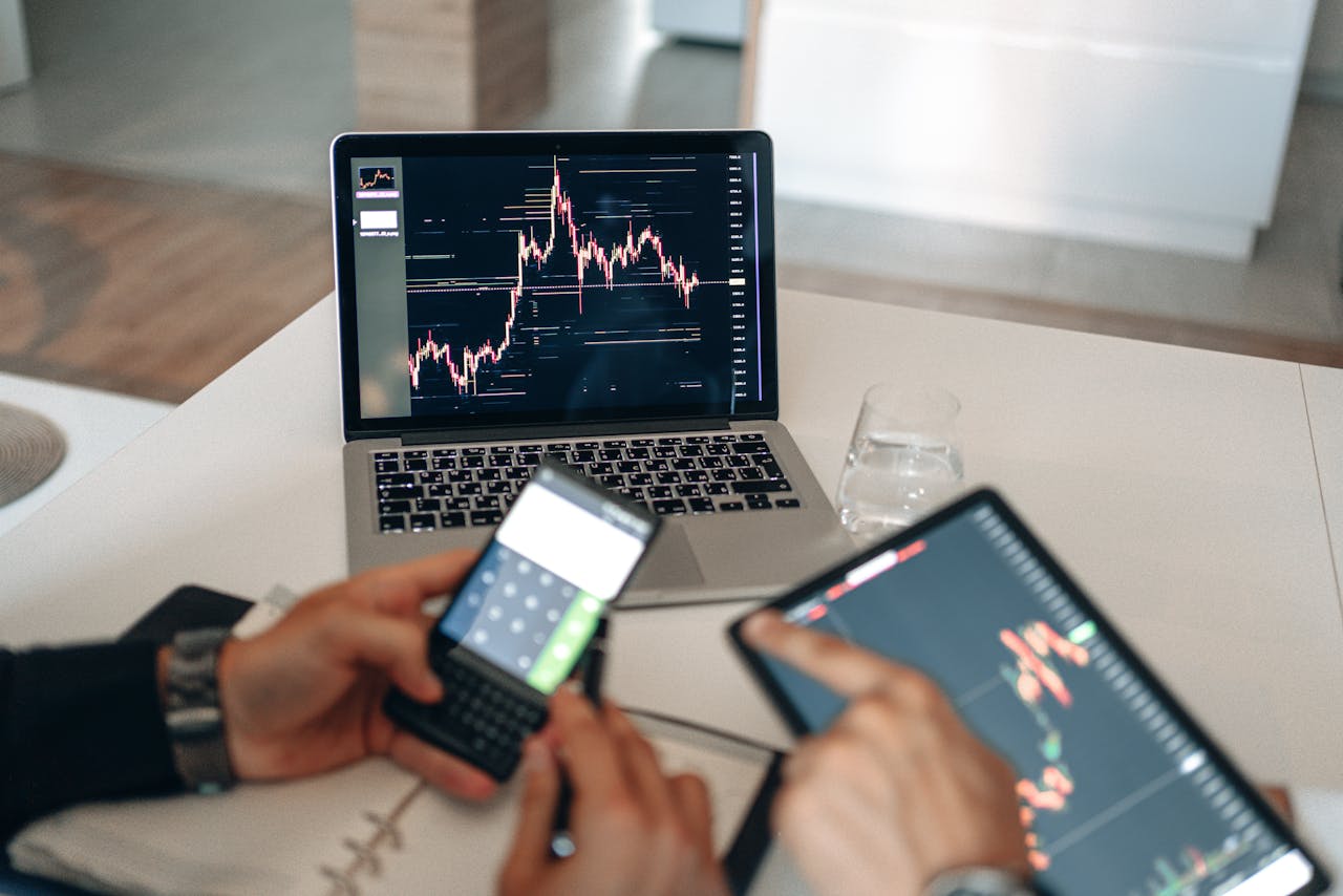 gallery-02 Hands using digital devices for financial analysis at a modern desk setup.